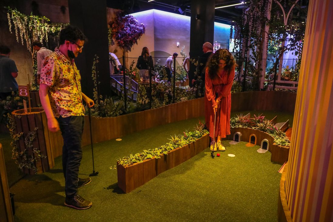 A miniature golf course, players and food